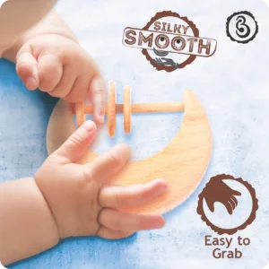Baby's hands grasping a "silky smooth" wooden moon toy.
