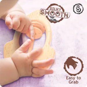 Baby's hands grasping a smooth wooden rattle.