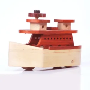 Slightly angled side view of a handmade wooden boat on white background.
